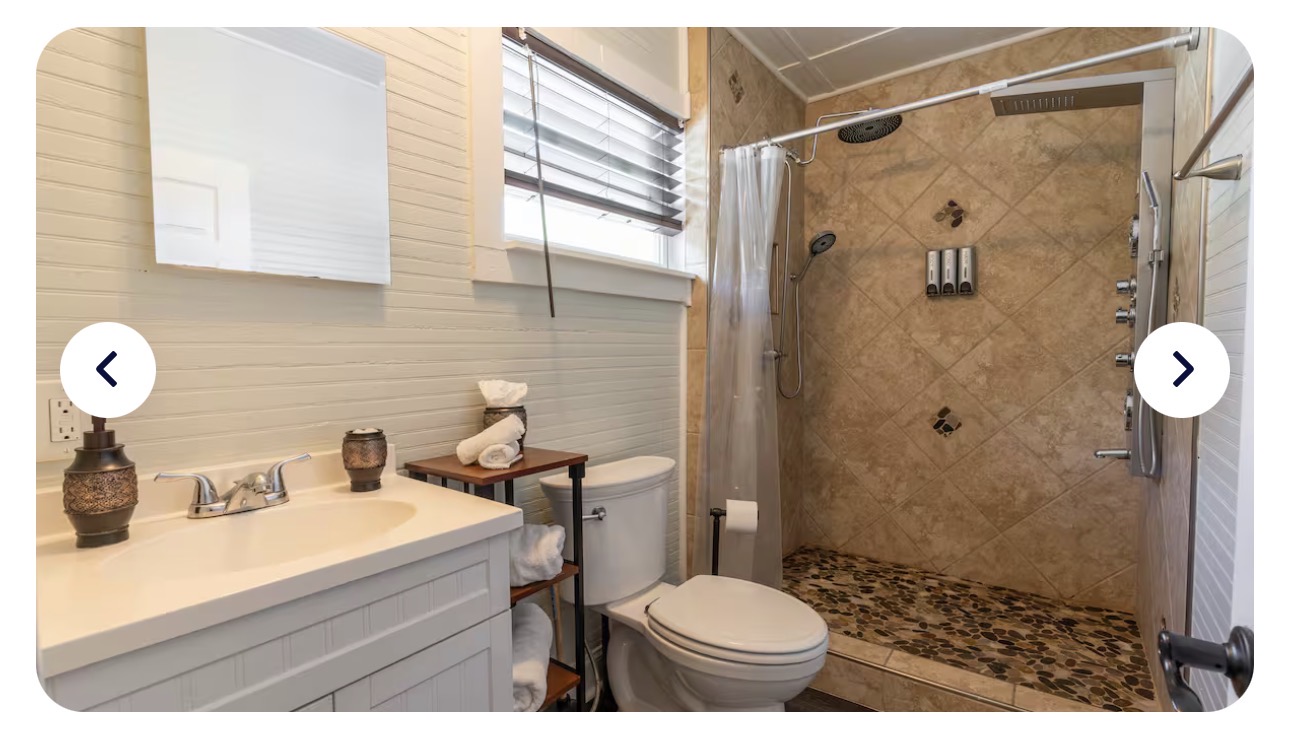 The Treehouse Suite spa shower — stainless multi-jet panel with rainfall head, handheld, and body jets
